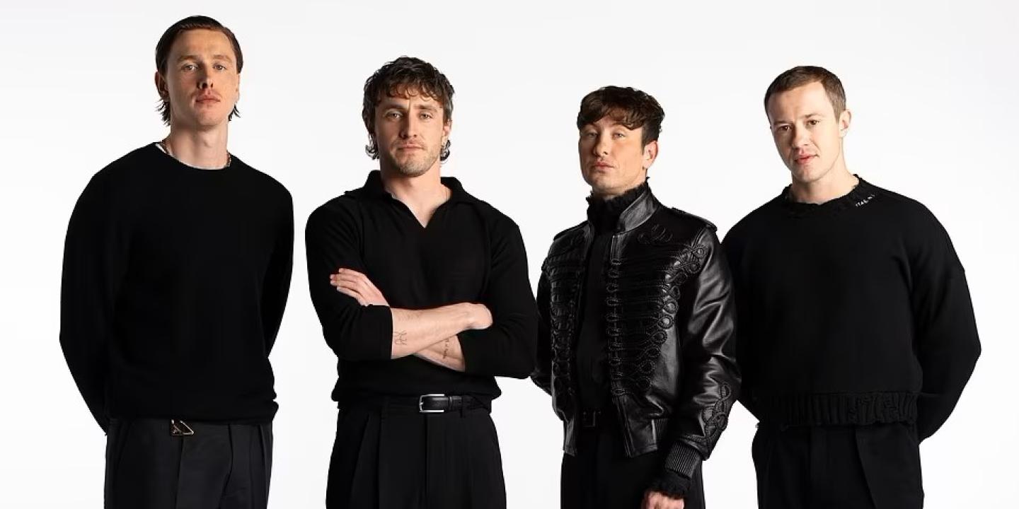 Four actors dressed in black stand together