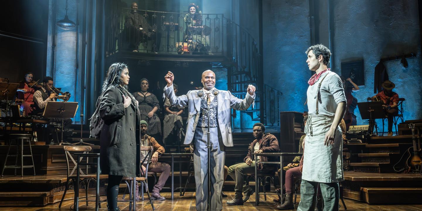 A theatrical staging shows a couple seperated by a man standing between them.