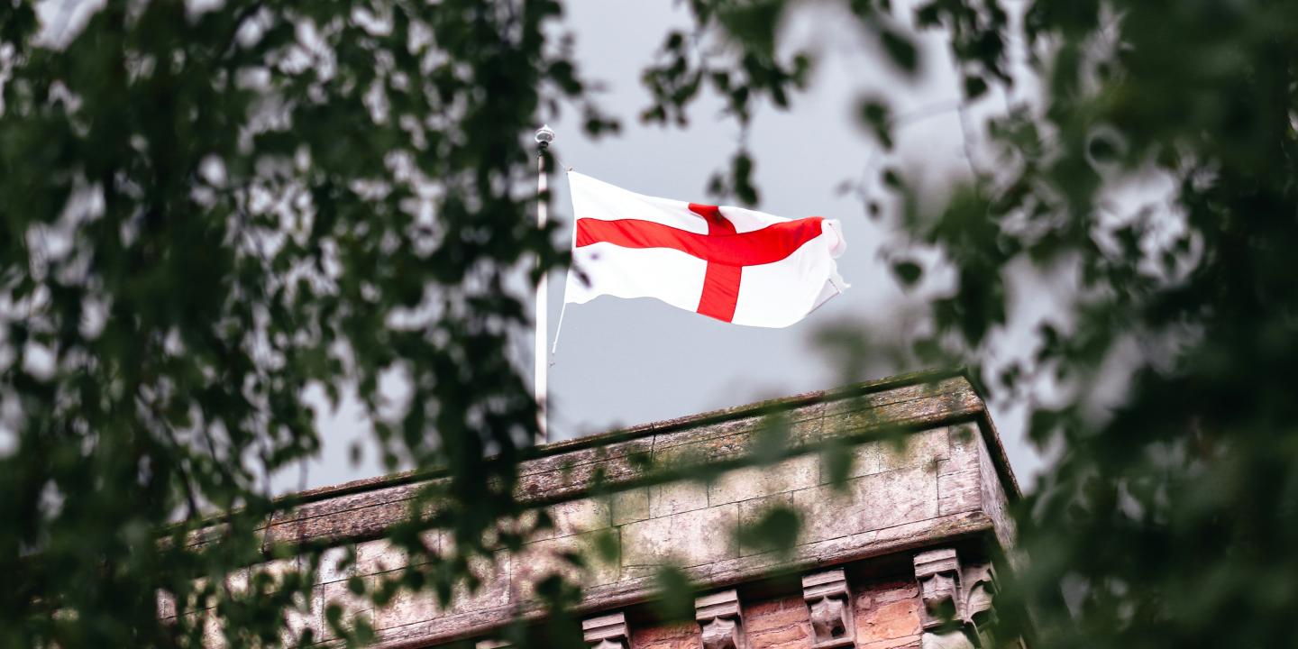 A St George's Cross flag flutters on a tower.