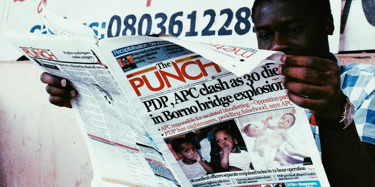A man reads a newspaper called The Punch.