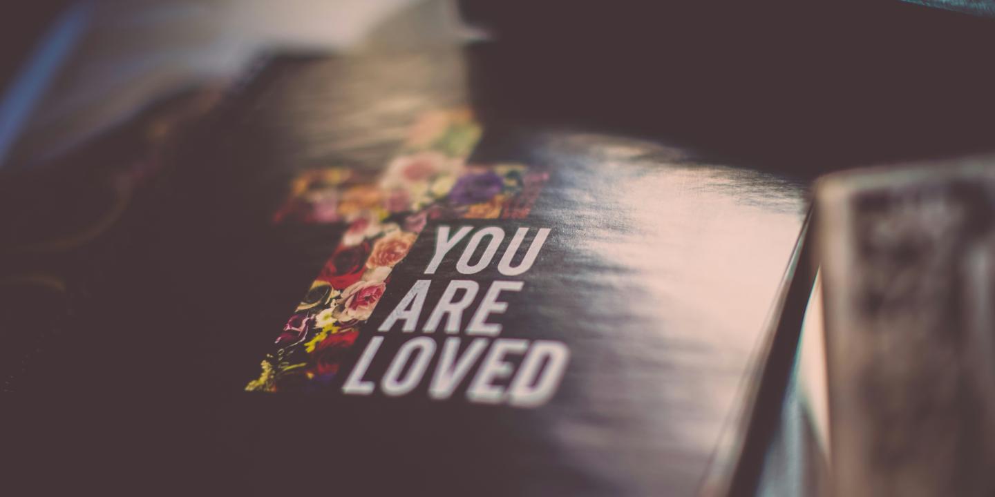 A cover of a book show a cross and the title 'You are loved'.