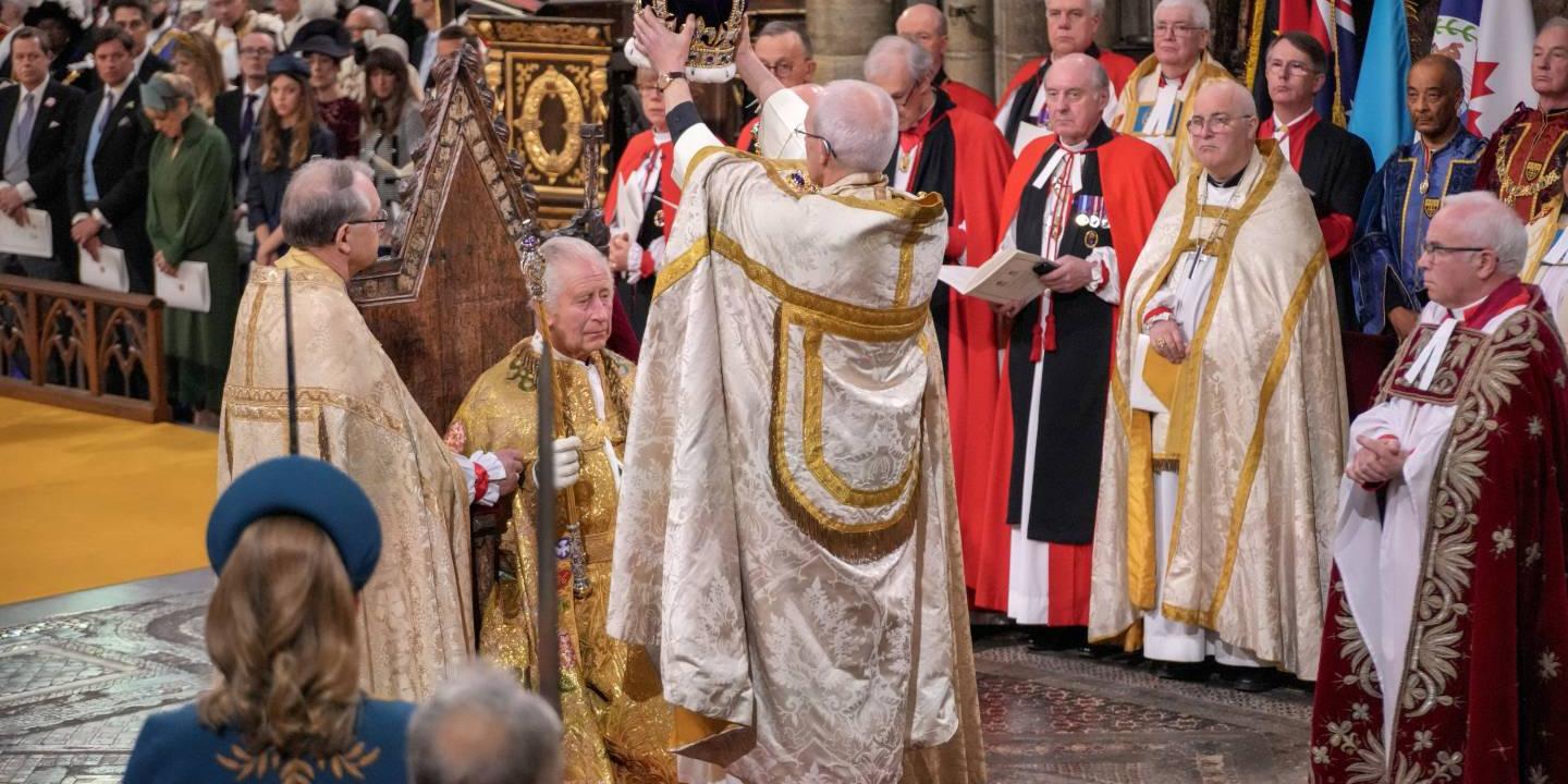 An archbishop raises a crown about the head of King Charles.