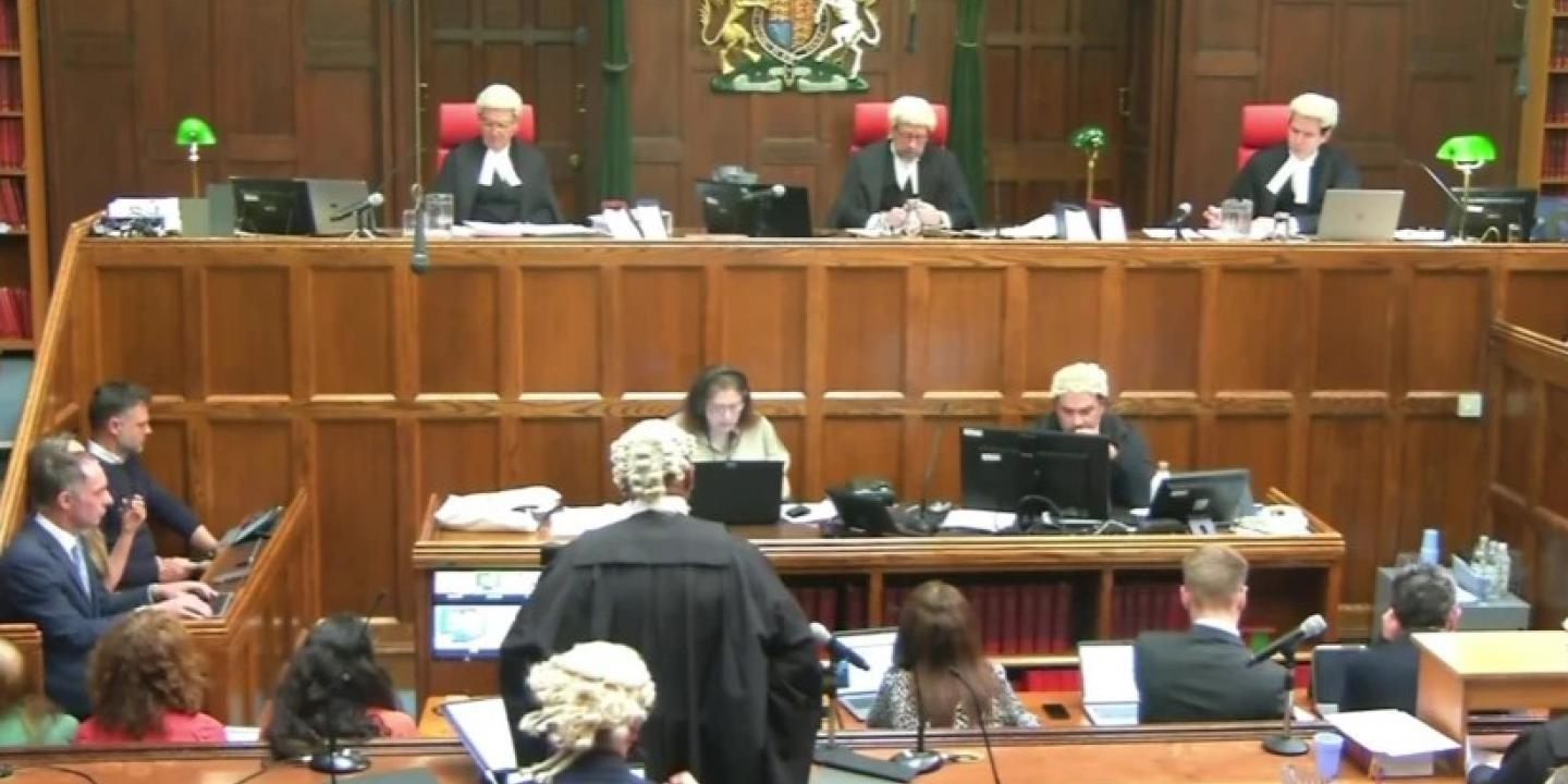 A court sits, with judges raised above the others.