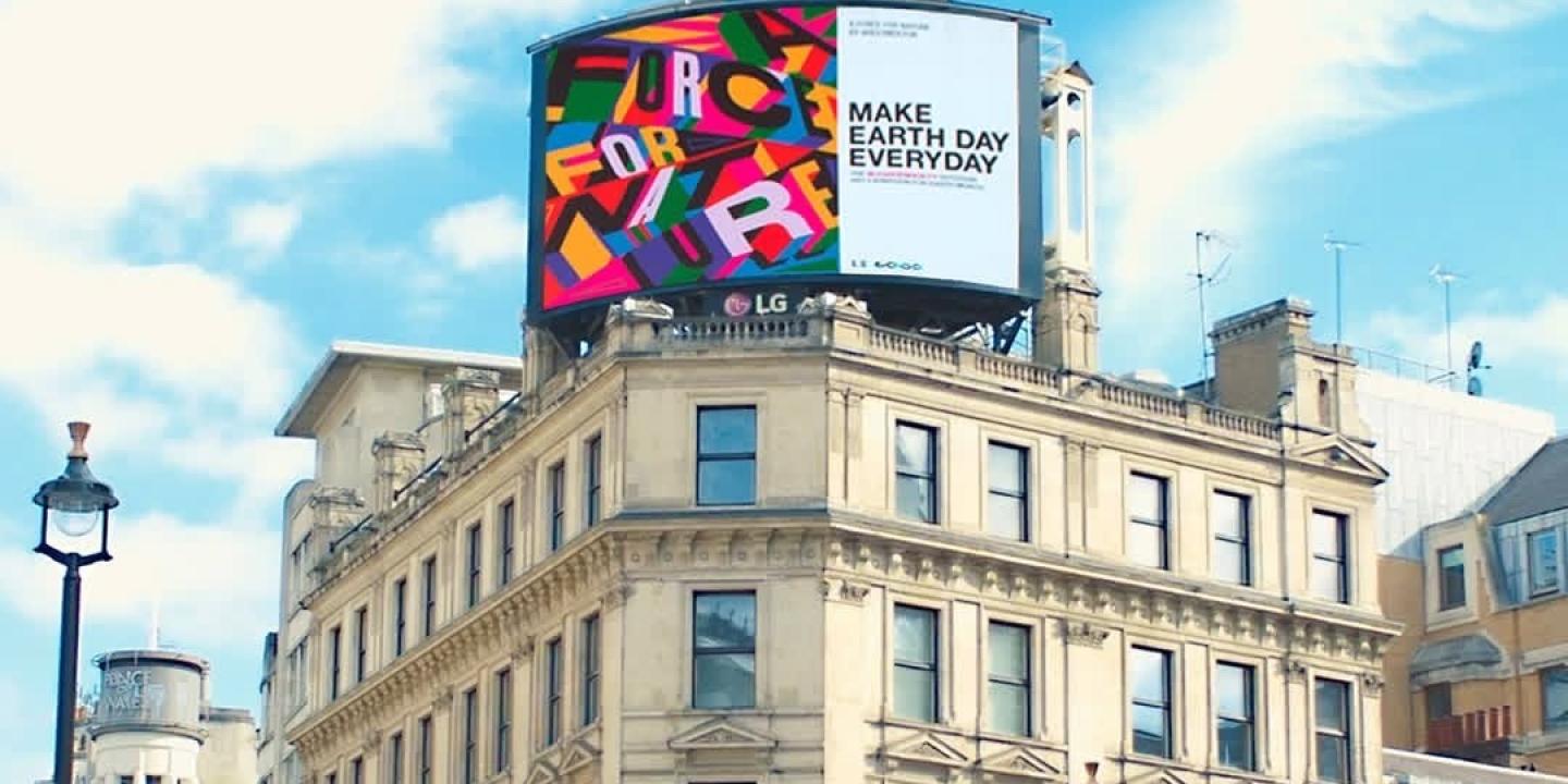 A digital billboard on top of a London building reads: Make Earth Day Everyday.