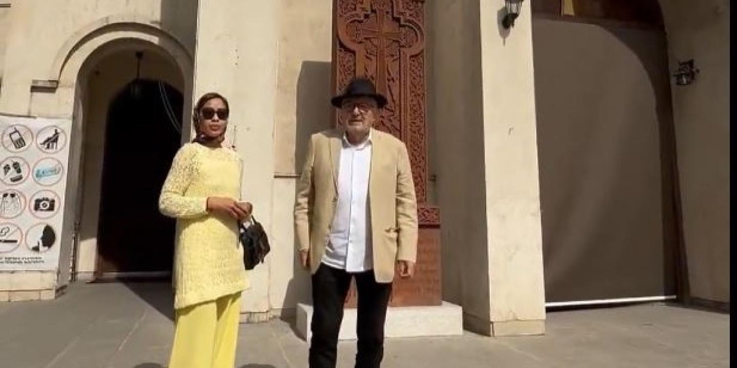 A couple stand on the steps of a cathedral in Iran.