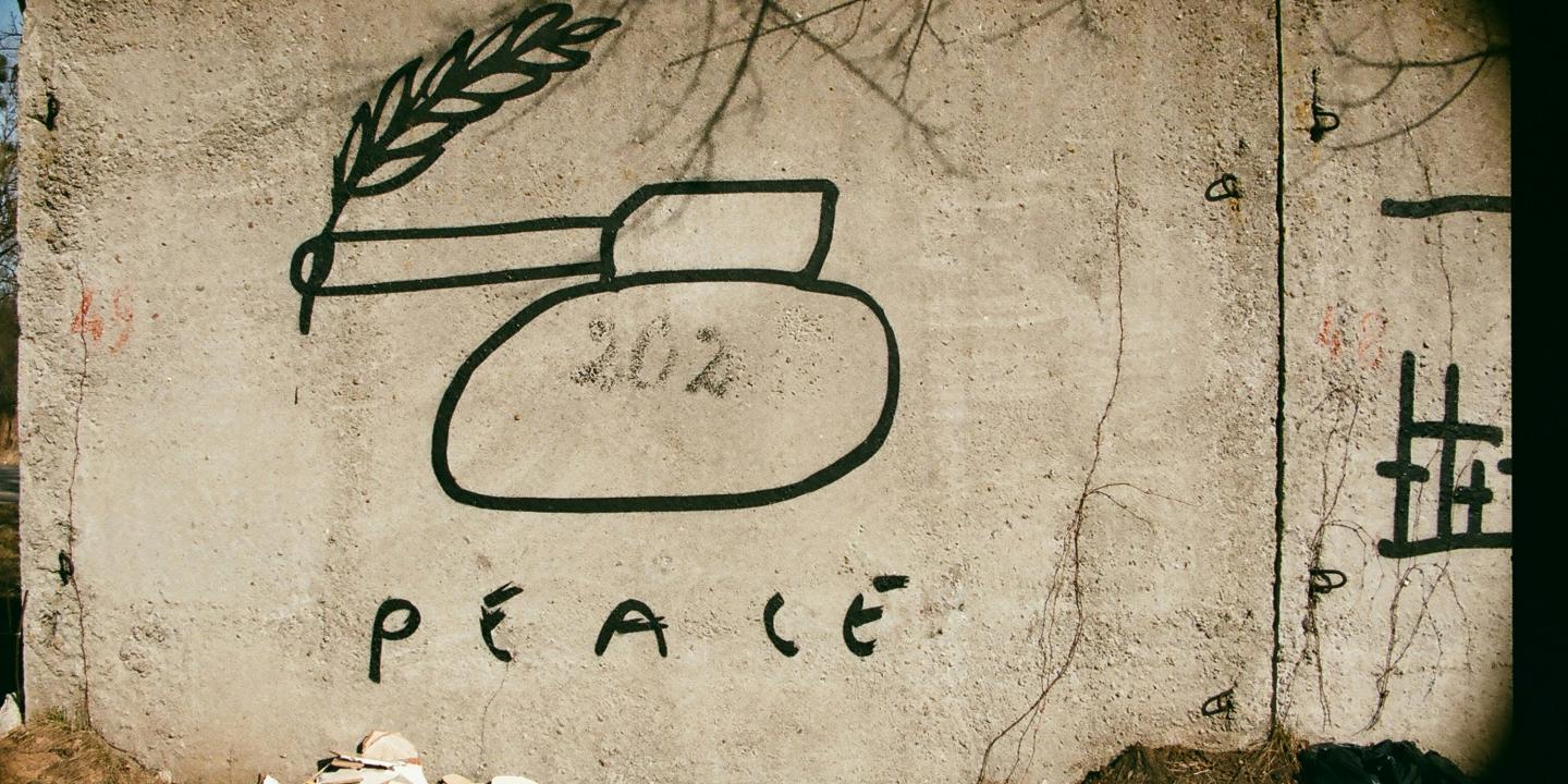 Graffiti of a tank with a peace laurel coming out of its barrel.