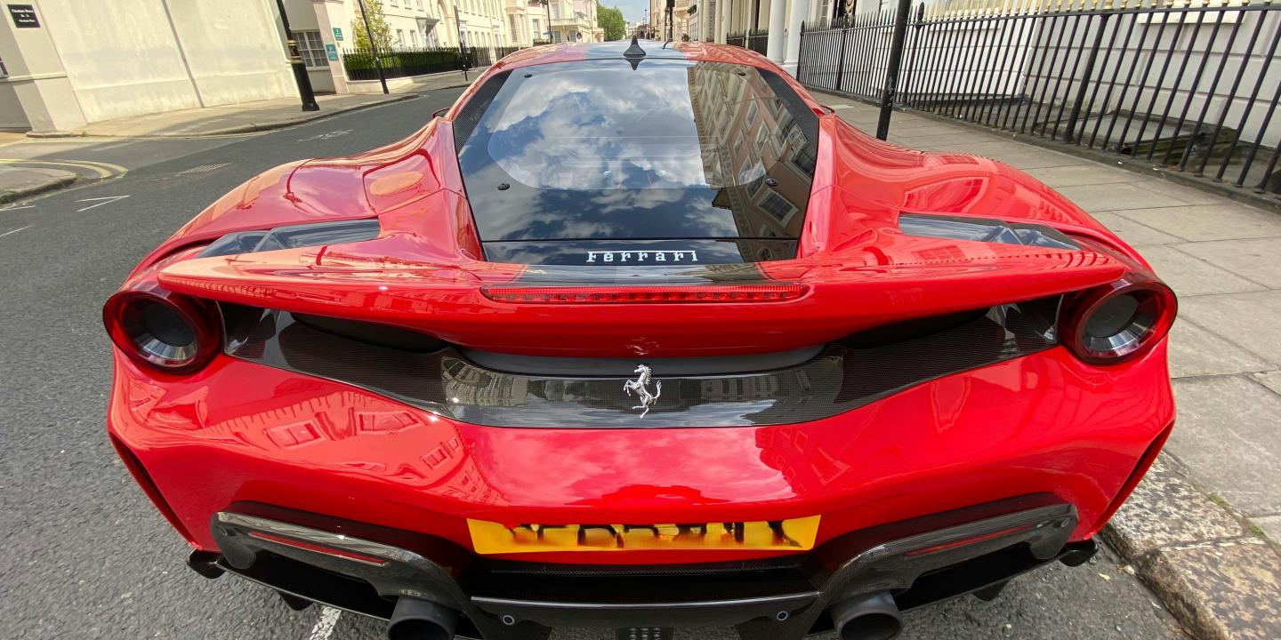 A red Ferrari parked on a posh London Street