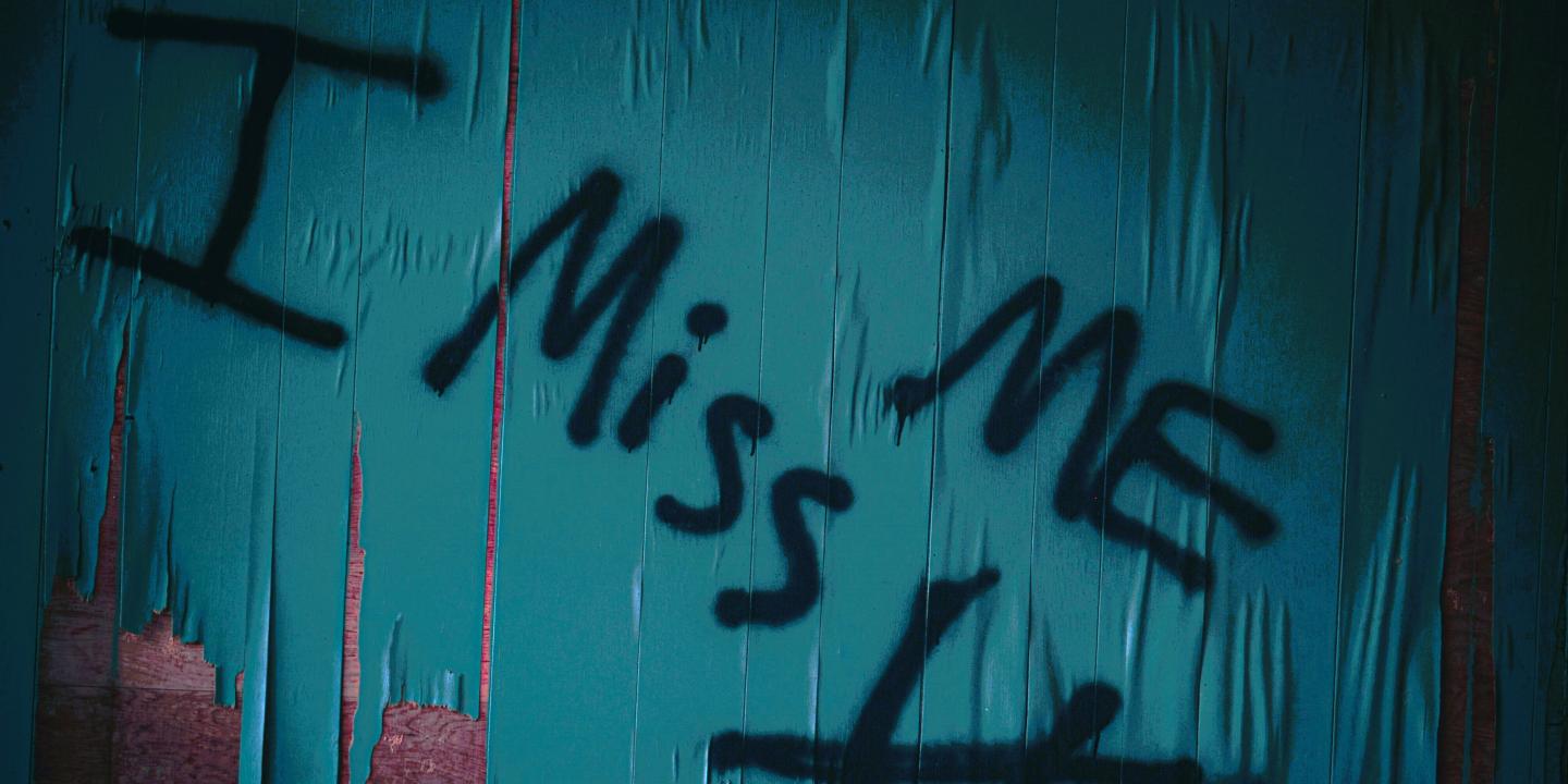 Graffiti reads 'I miss me' with u crossed out under the 'mem'
