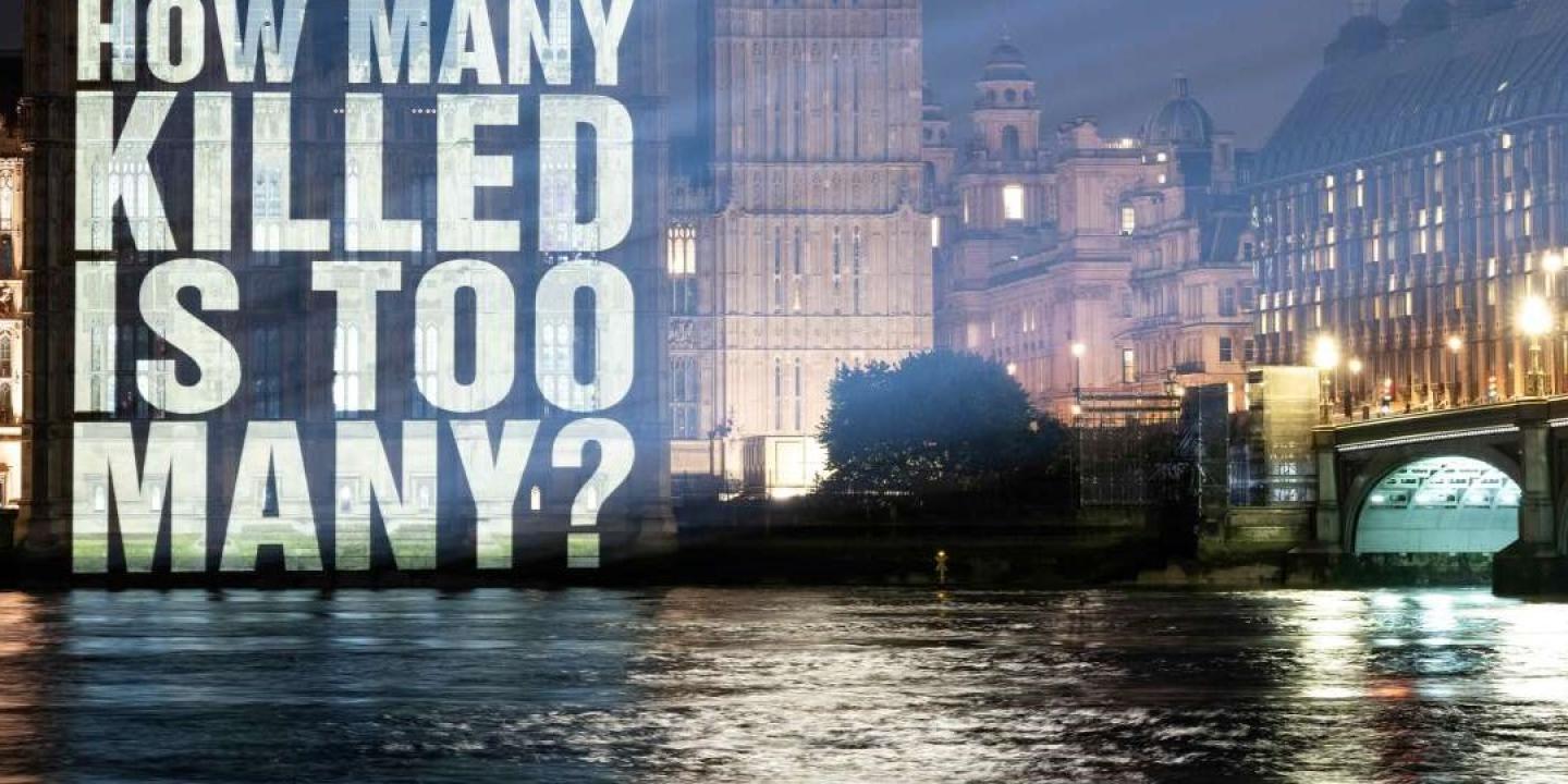 A sign projected on to the Houses of Parliament reads: how many is too many.