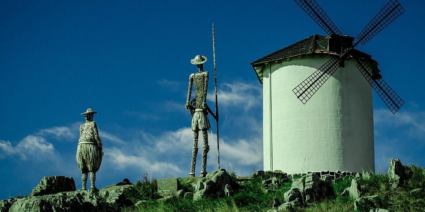 Statues of Don Quixote and Sancho Panza point toward a windmill