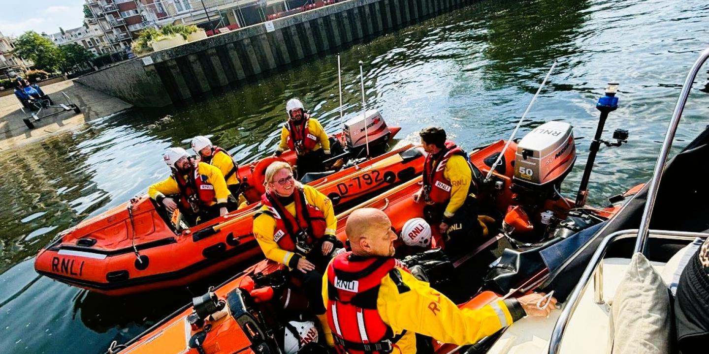 Two small lifeboats raft together on a river rescue.