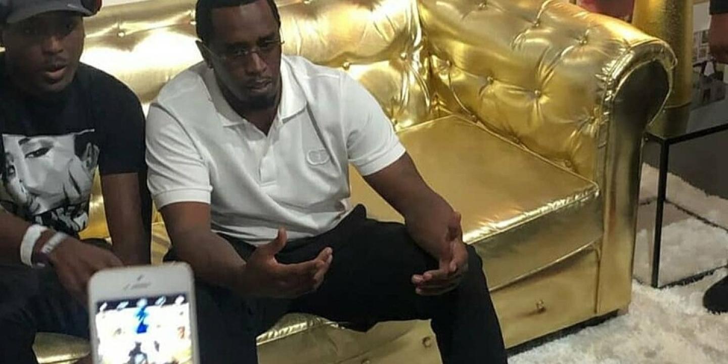 Sean Combs sits on a golden couch.