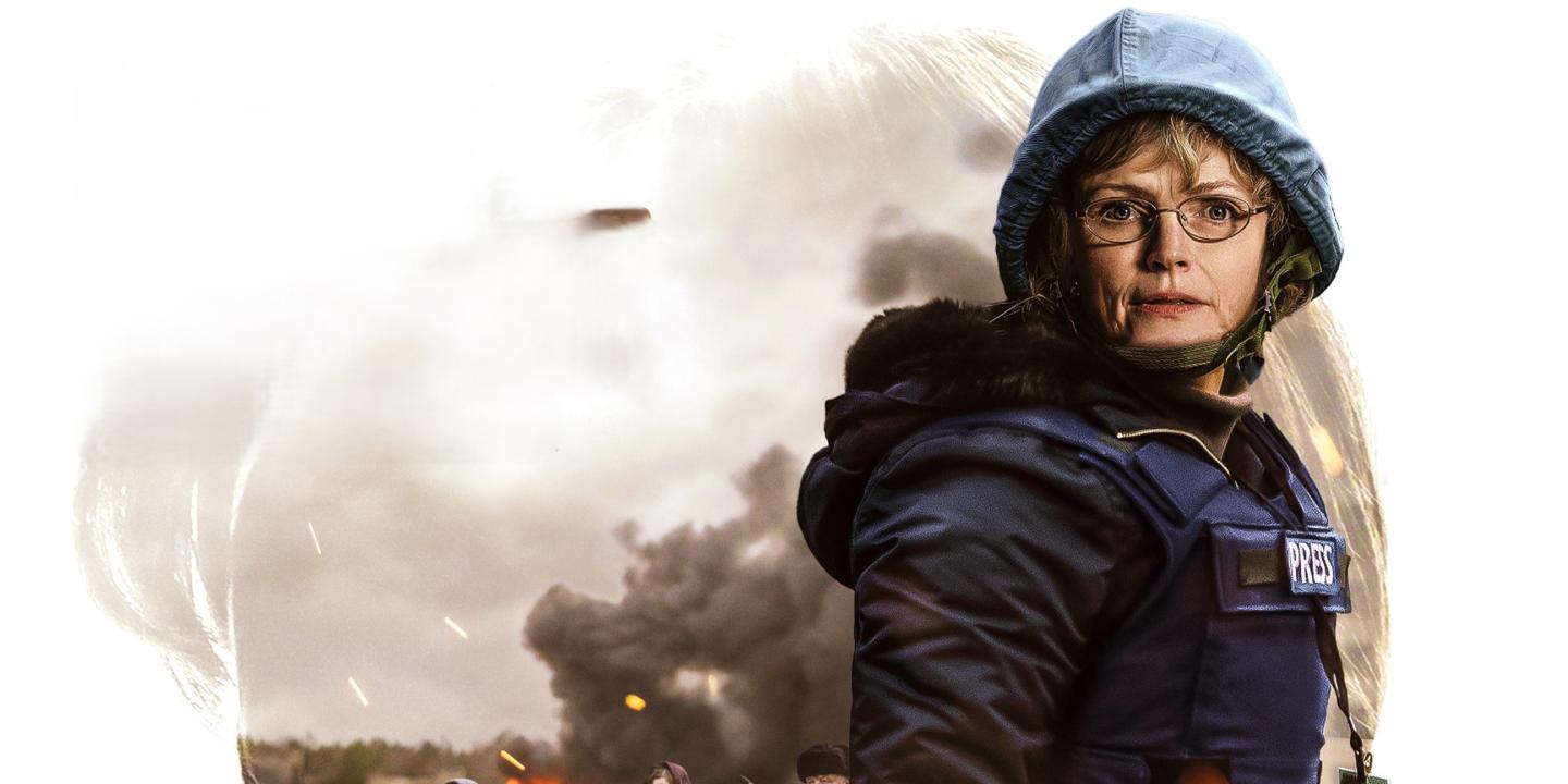 A journalist wearing a body armour and a helmet looks defiant