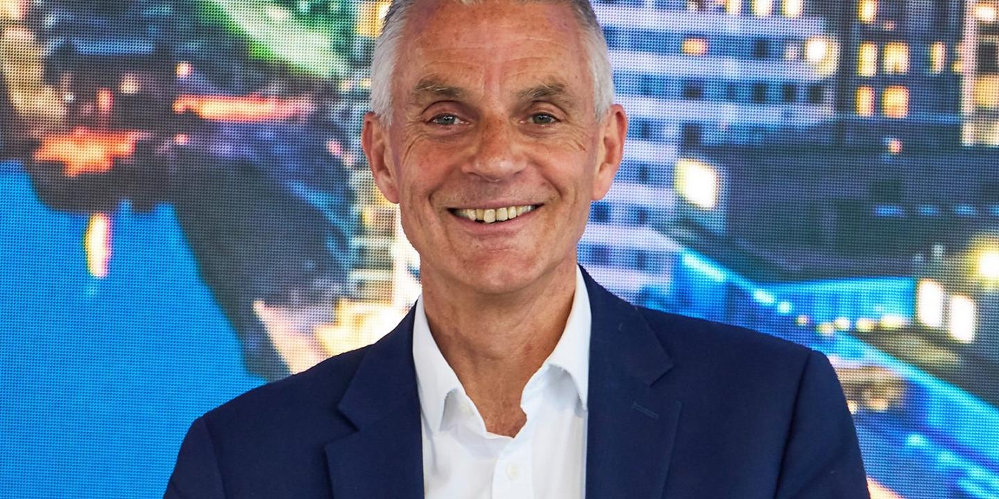 Tim Davie in a blue suite smiles