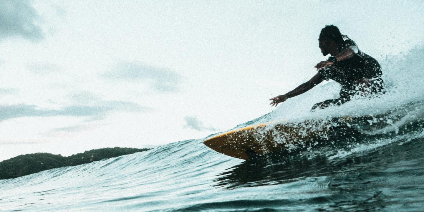 A surfer carves a turn on a wave.