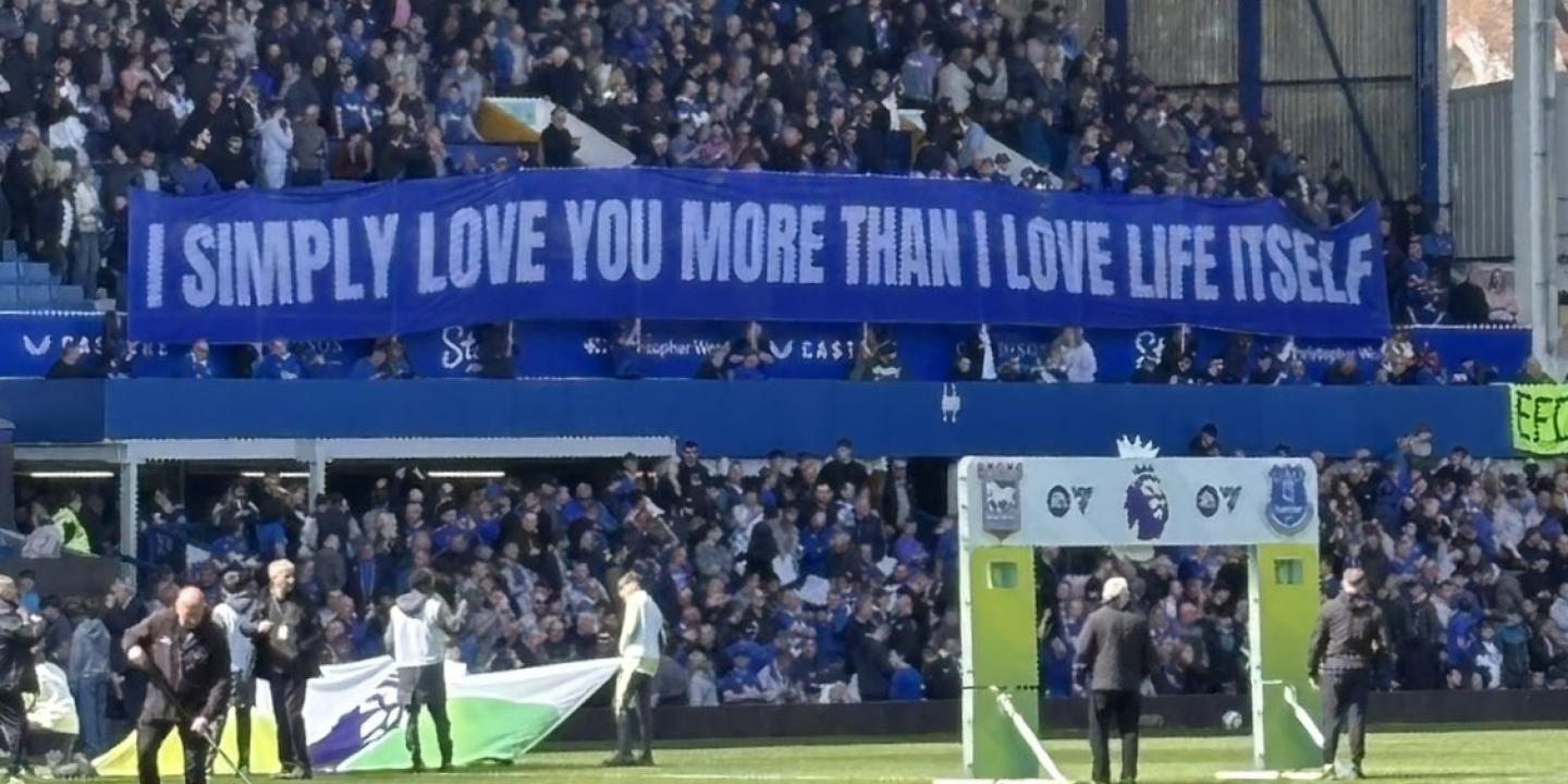 A football stand displays a long banner with text on it.