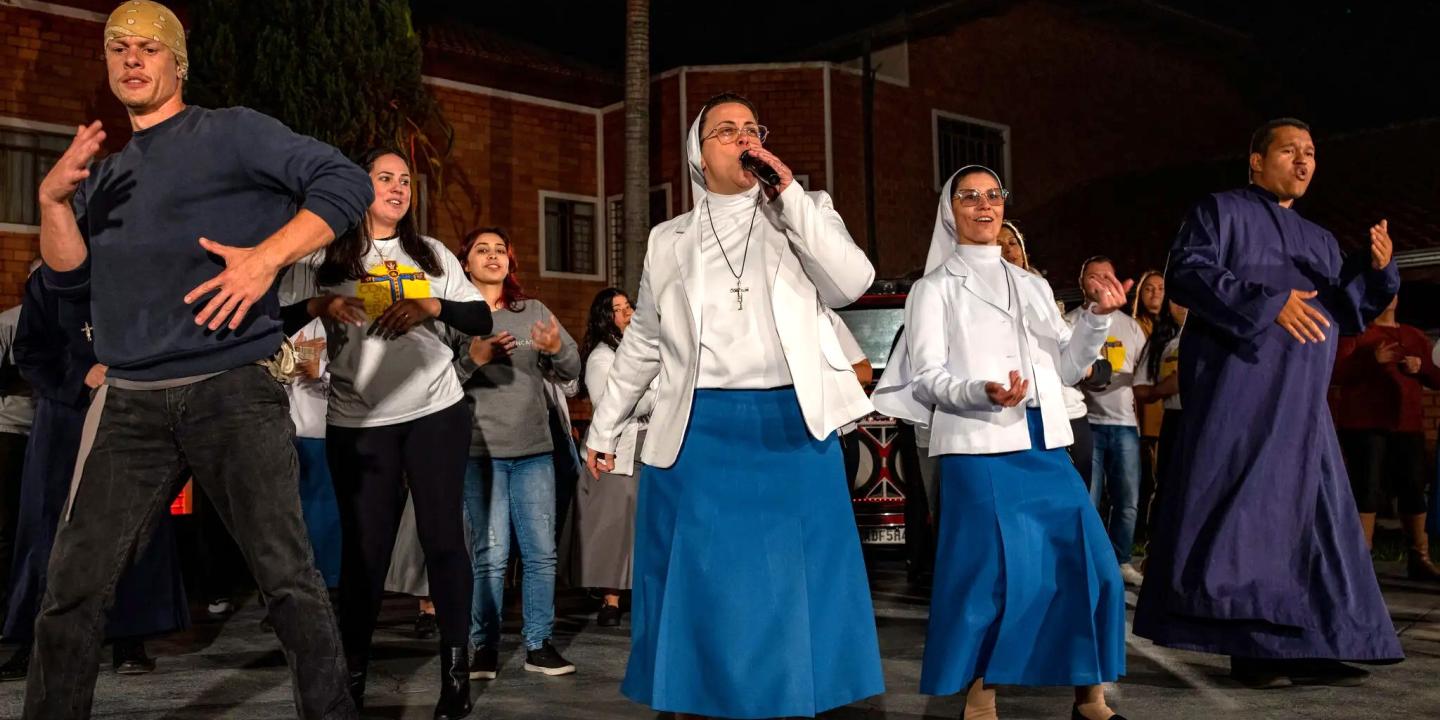 Two nuns with a band rap on stage
