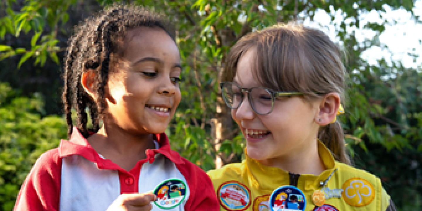 Two Brownies point out their badges.