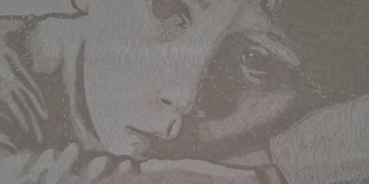 A sand drawing shows an unhappy child's face with the tide coming in from below