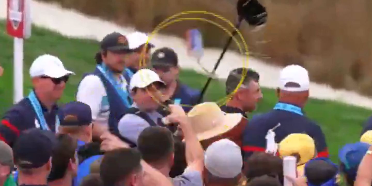 A video still shows a beer can thrown at a golf amid a crows