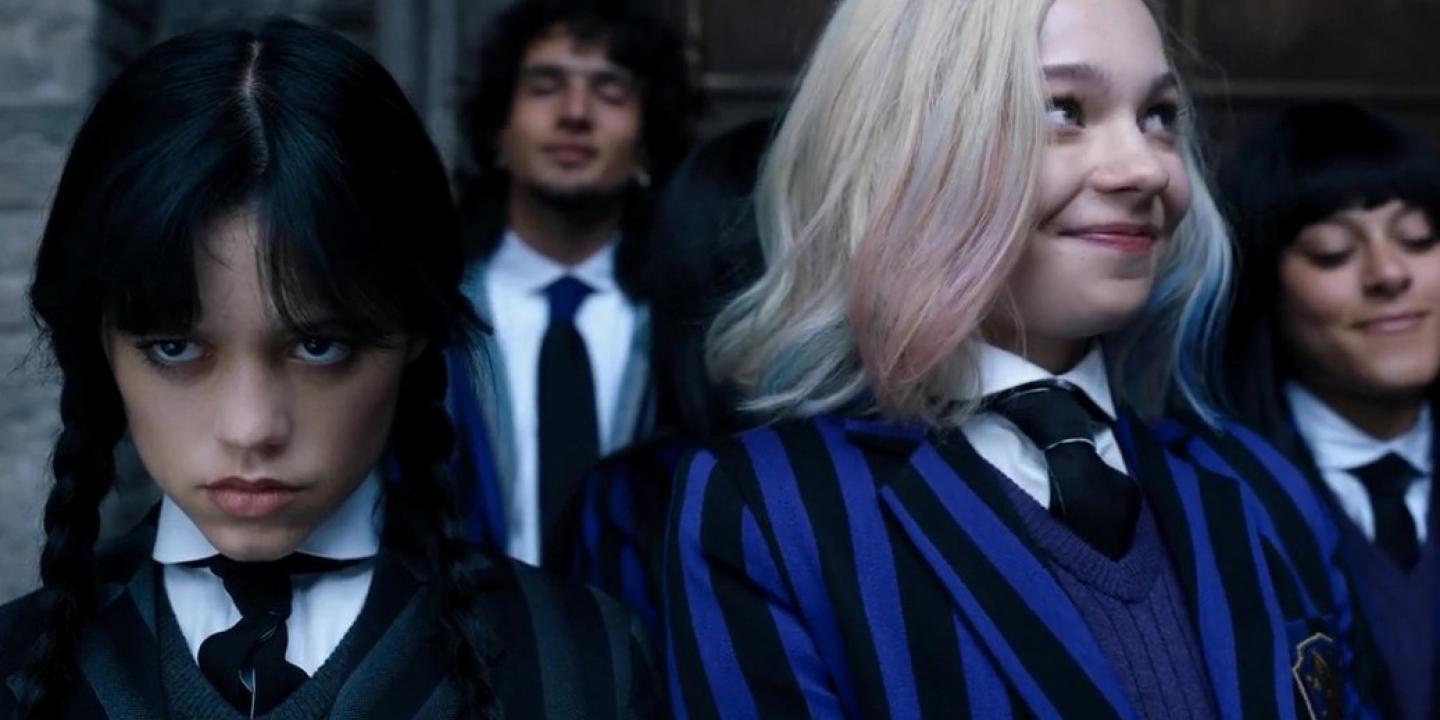 Wednesday Adams scowls while Enid smiles.
