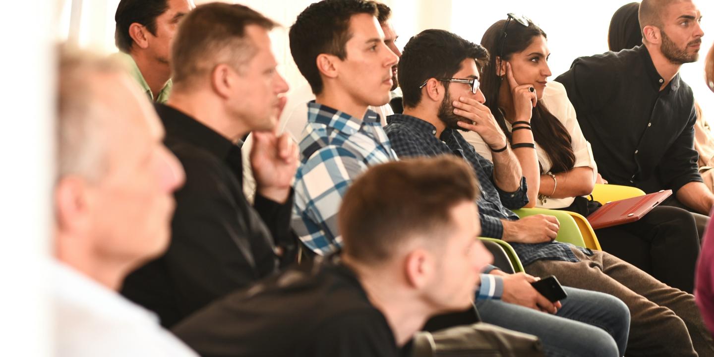 young people listen, and ponder, to a speaker off screen.