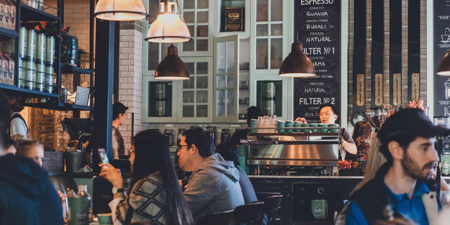 People sit in a busy cafe.