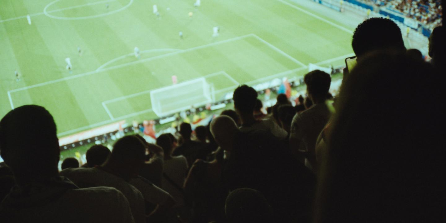 A view from a football stand over heads to the pitch.