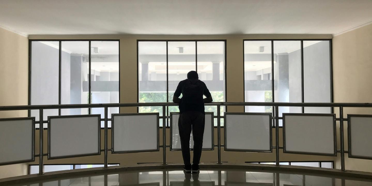 A person leans on a balcony rail.