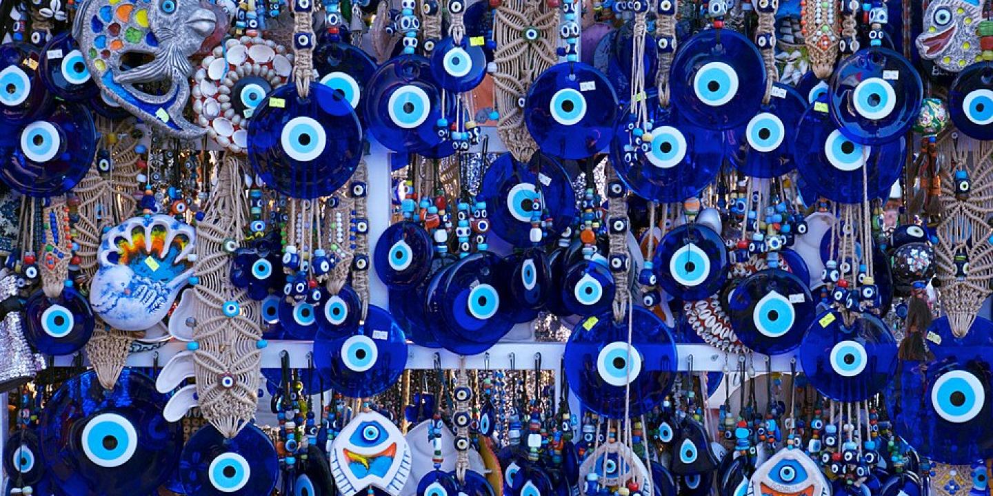 Blue evil eye charms hang among a jewellery display