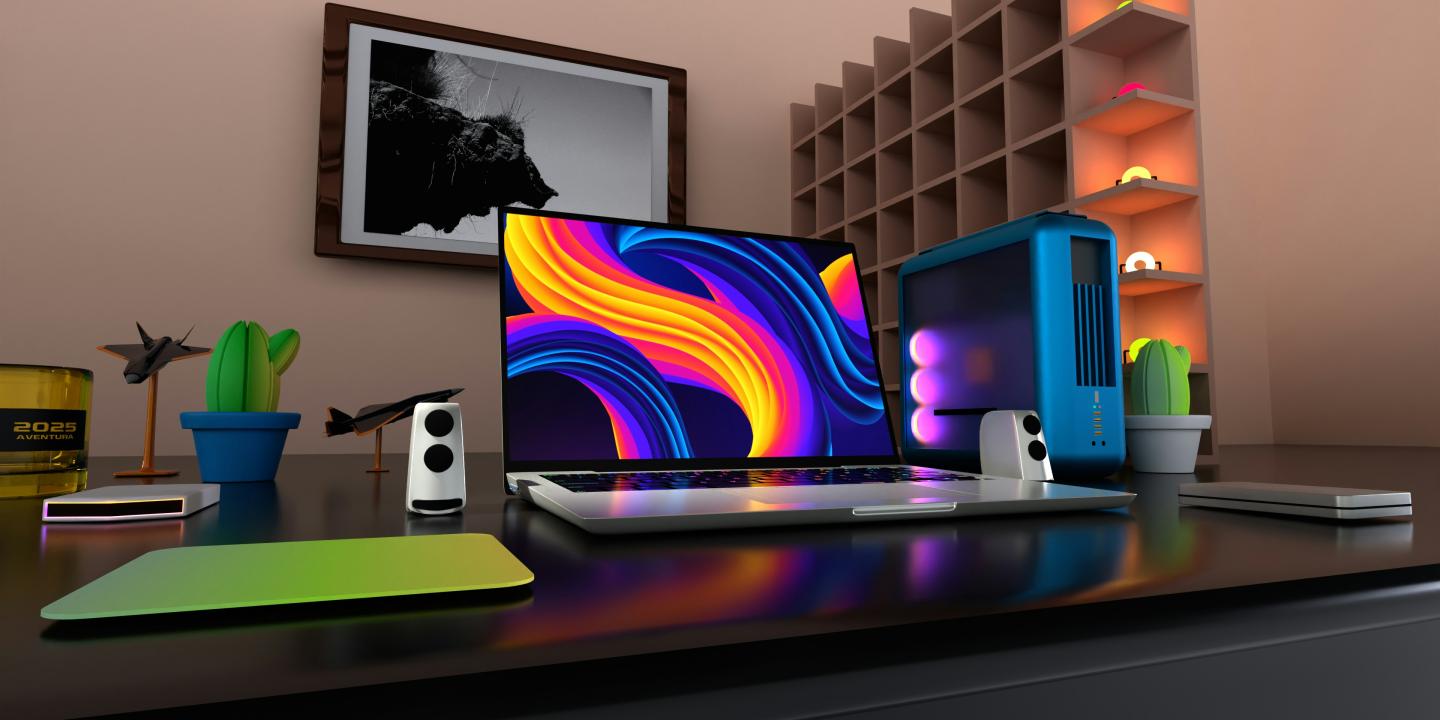 A flat screen on a desk displays a colourful pattern.