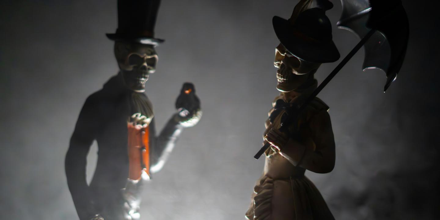 Skeleton figurines clothed in Victoria outfits.