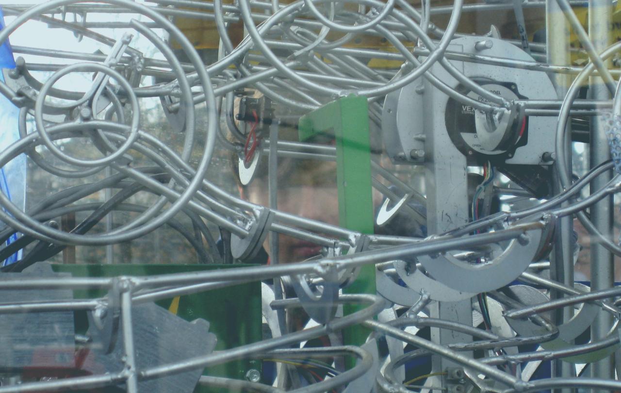 A complex of linear and metal parts in a machine-like sculpture.