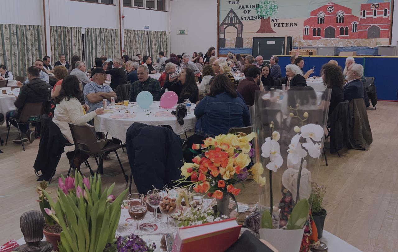 Community members celebrate at lunch in a church hall