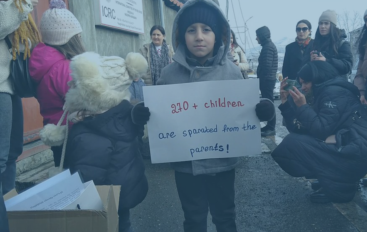 A child protestor holds a placard at a demonstration