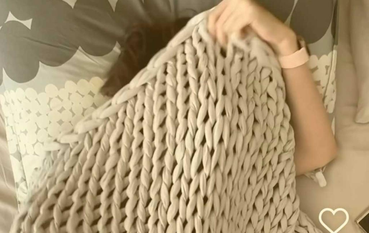 a sleeper pulls a blanket up over their head.