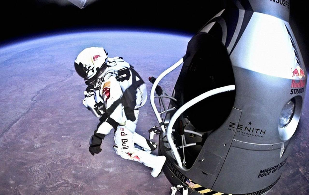 A skydiver in a space pressure shoot leaps from a capsule above the earth.