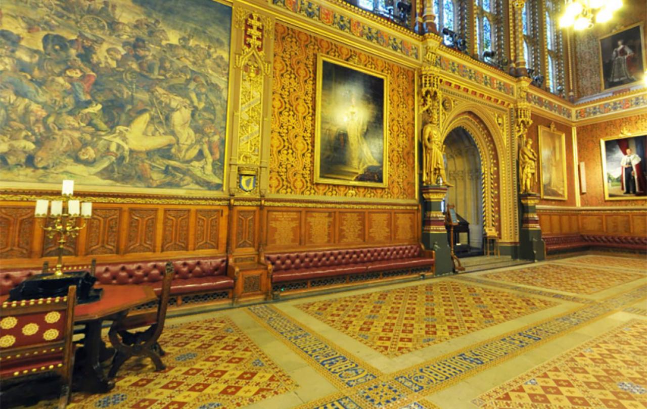 A grand highly dercorated hall in the neo-gothic style, with encaustic tiles in the foreground.