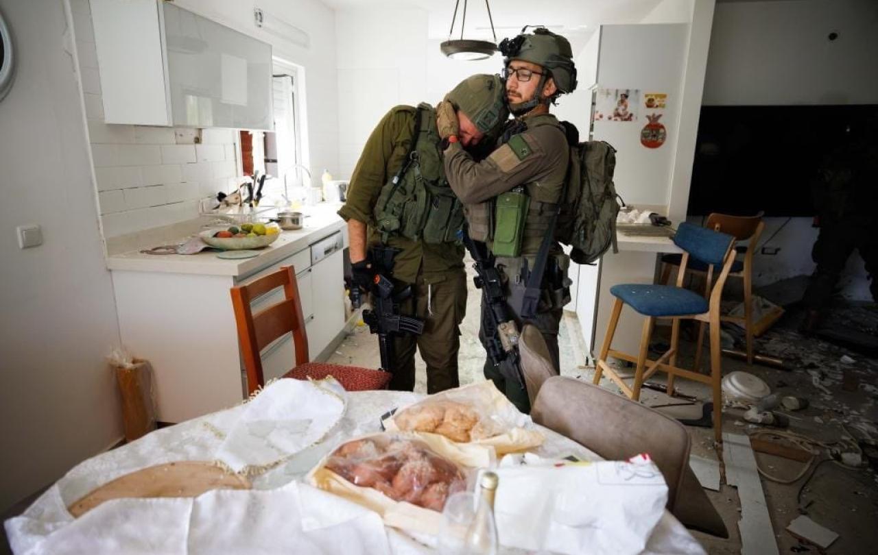 Two soliders console each other as they search a house that has been ransacked.