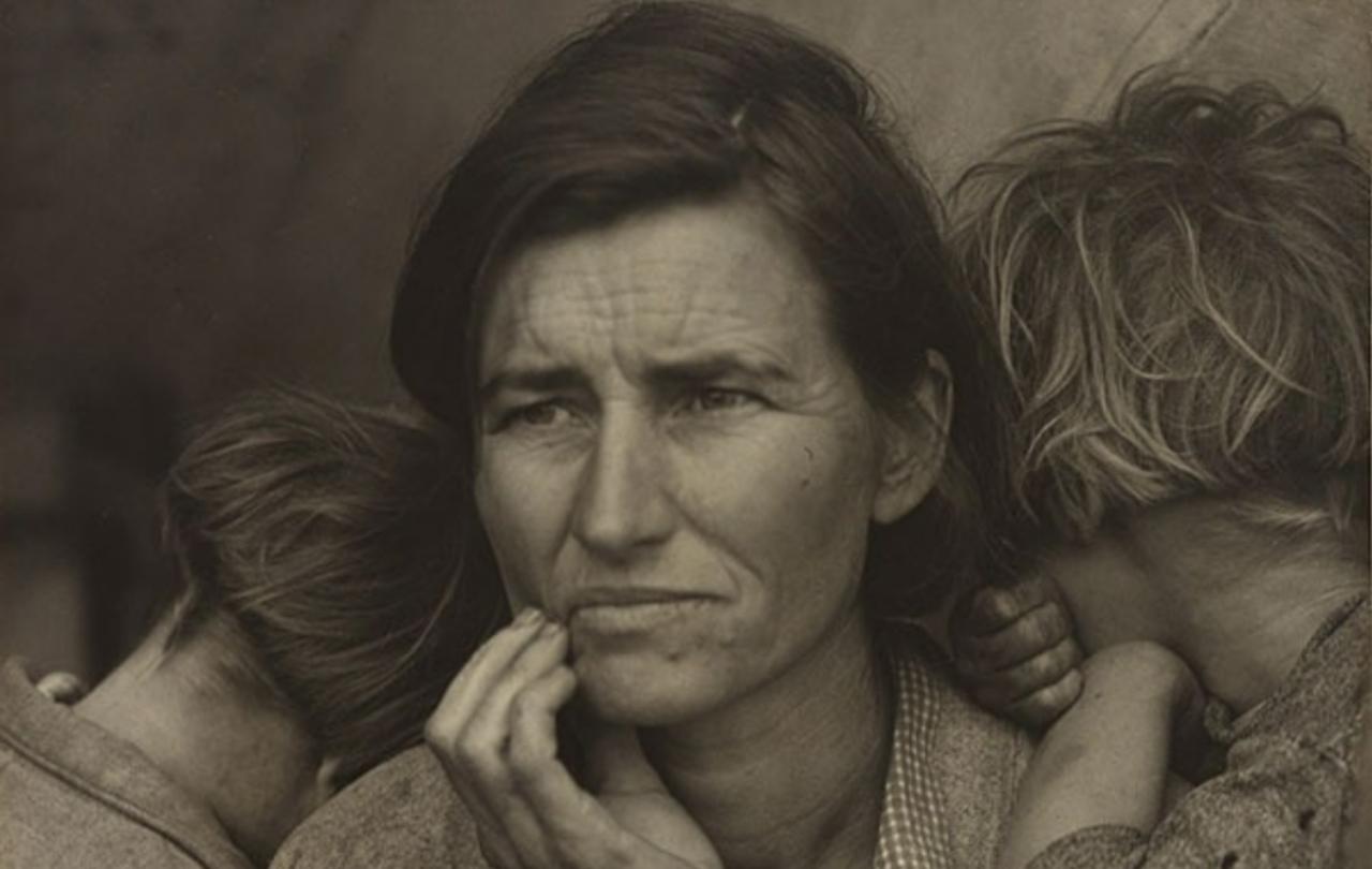 A black and white close up of a mothers cradling her jaw in worry as children cuddle into her.