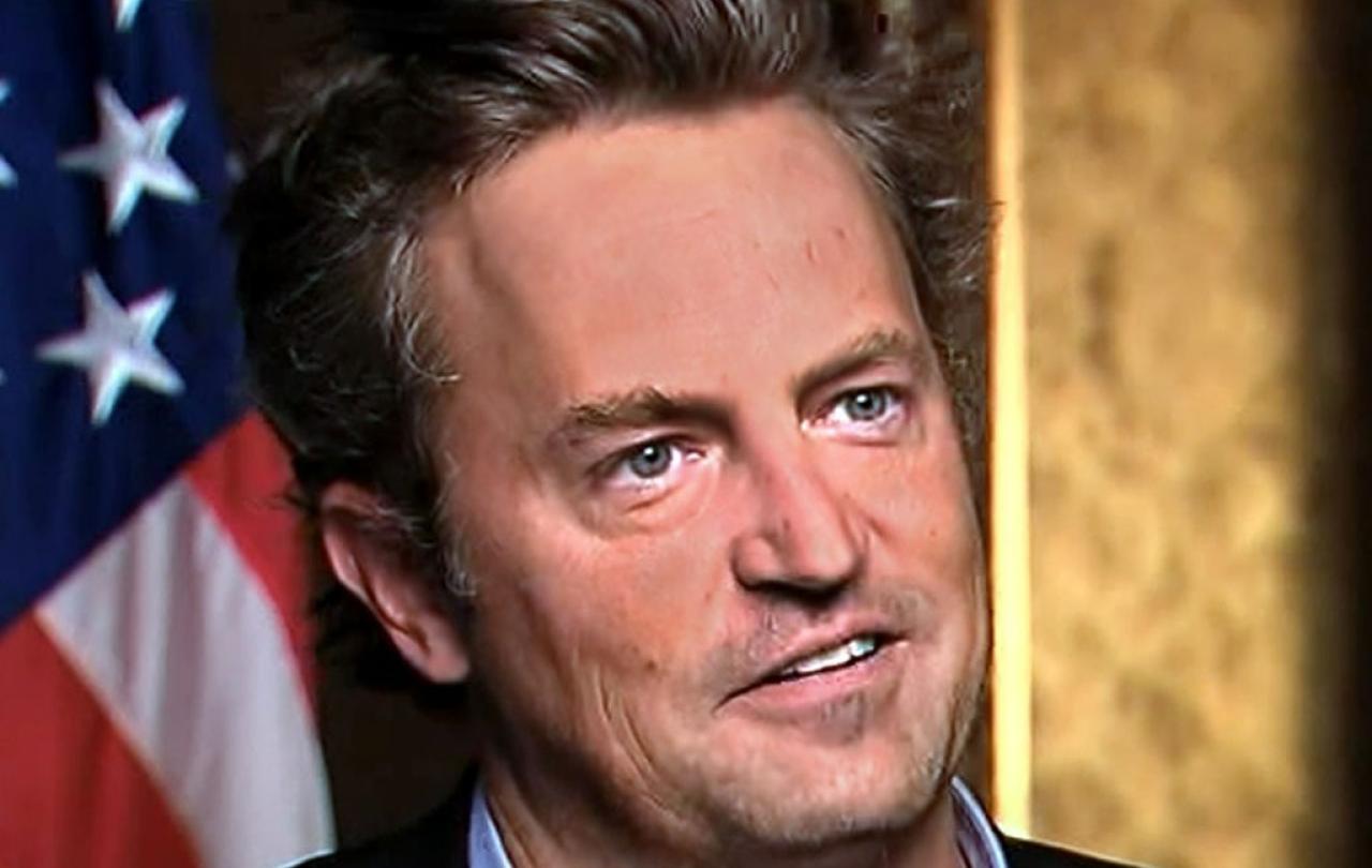 Actor Matthew Perry looks formally away, with a US flag in the background