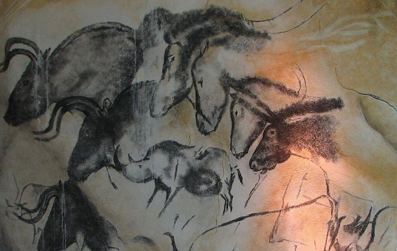 A cave wall drawing of wild animals galloping across other images of themselves.