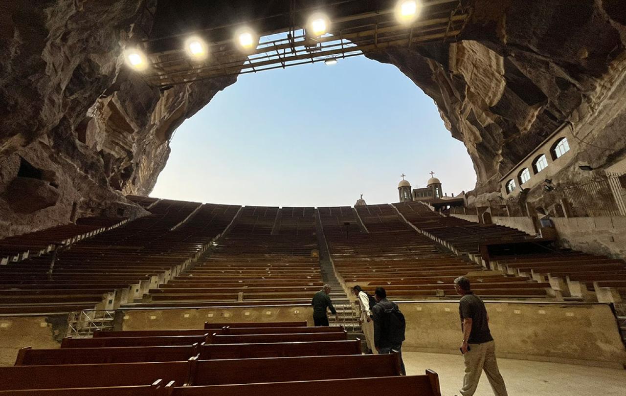 a view from the bottom of a huge cave to the sky, up row upon row of seating tiers.