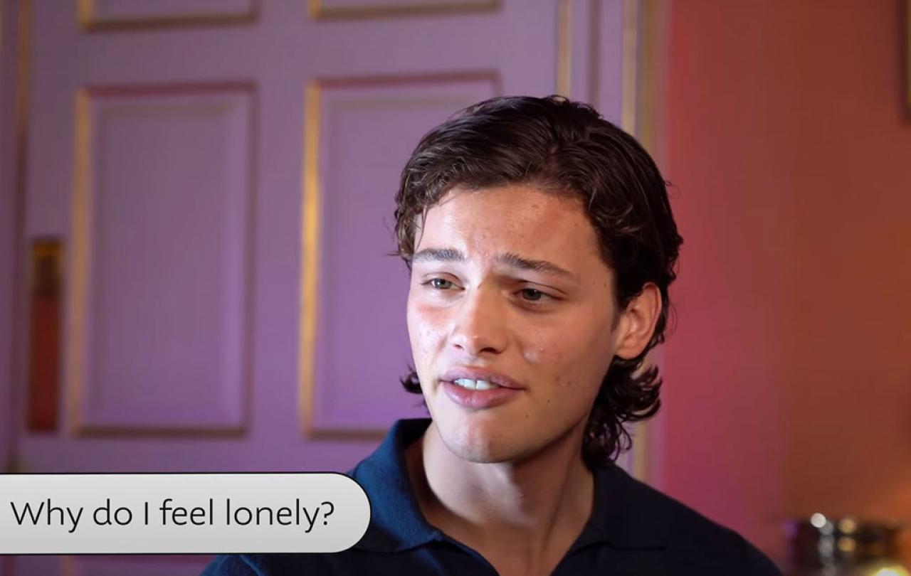 a young man looks pensive as he answers a questuon while sitting in a fancy room.