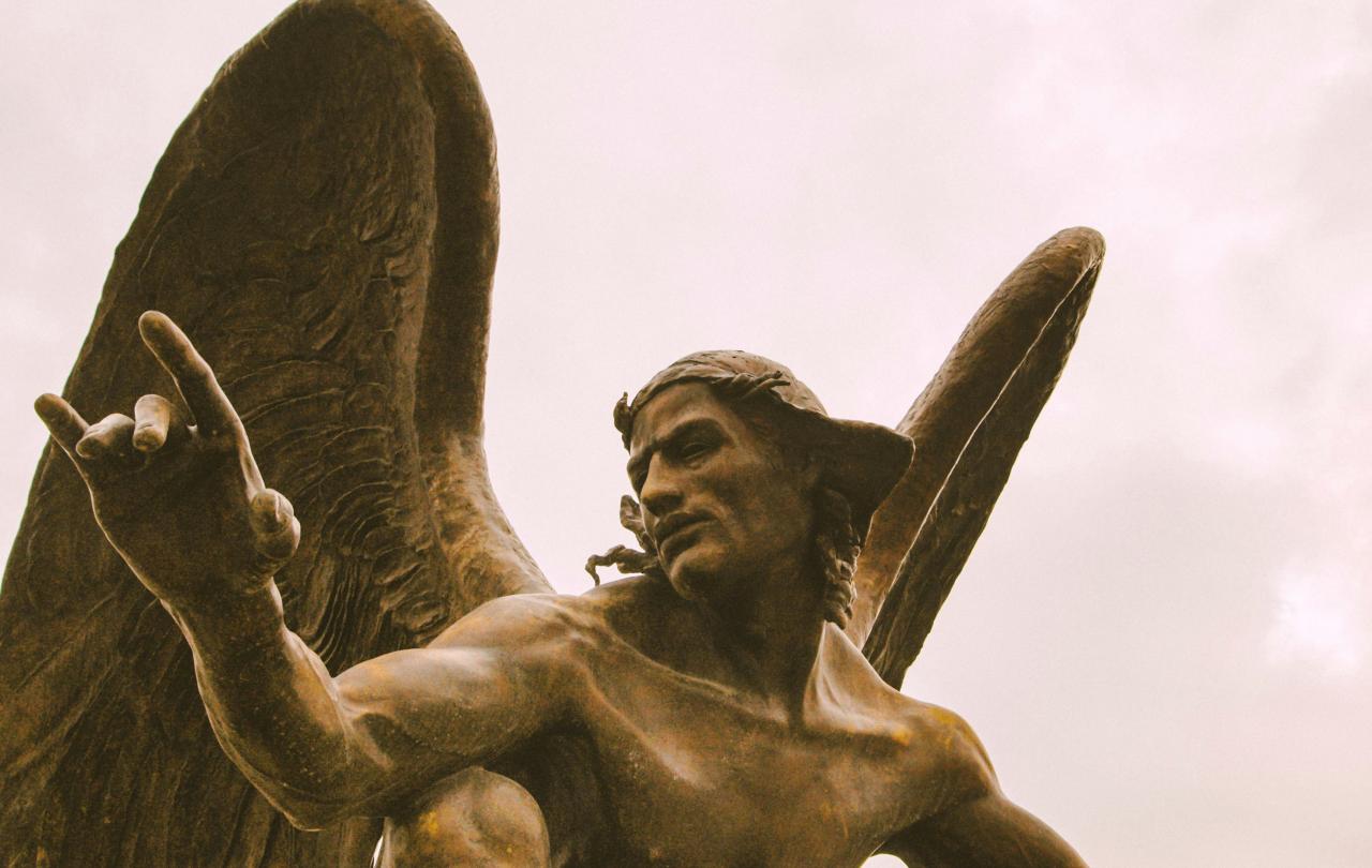 A statue of an angel crouching and gesturing with one hand.