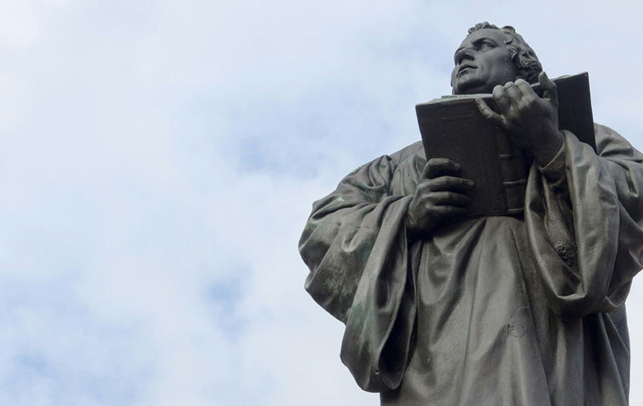 Looking up at a statue of Martin Luther holding an open bible.