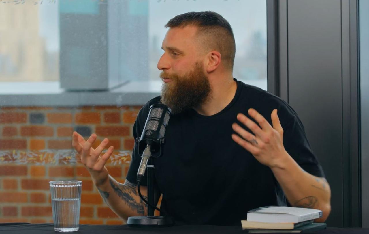 A guest on a podcast, gesture in front of a microphone.