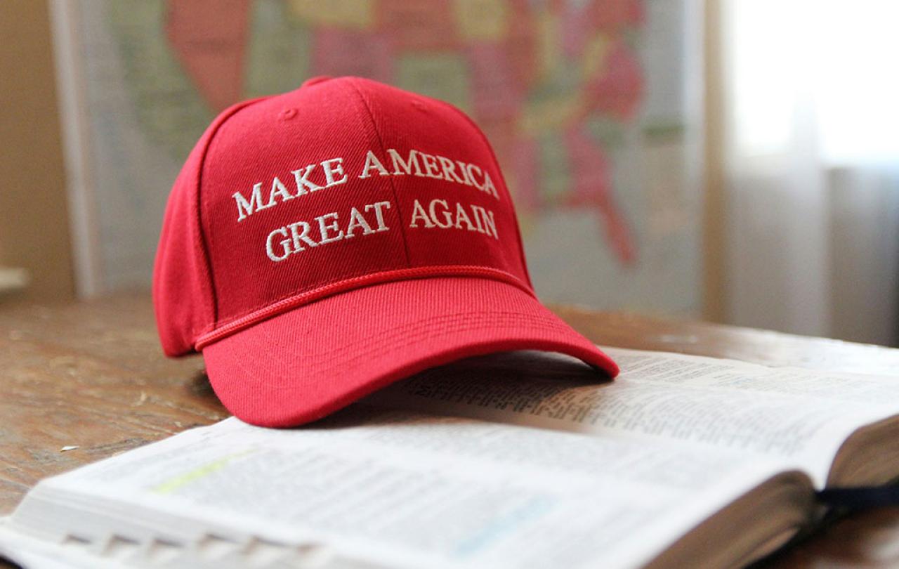 A red baseball cap, with Make America Great Again written across it, sits on an open bible.