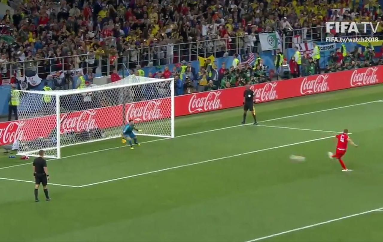 A footballer takes a penalty kick.