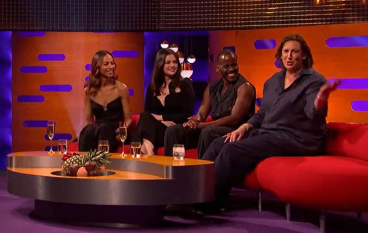 On a TV chat show, guests look to one of their own talking to the audience. 
